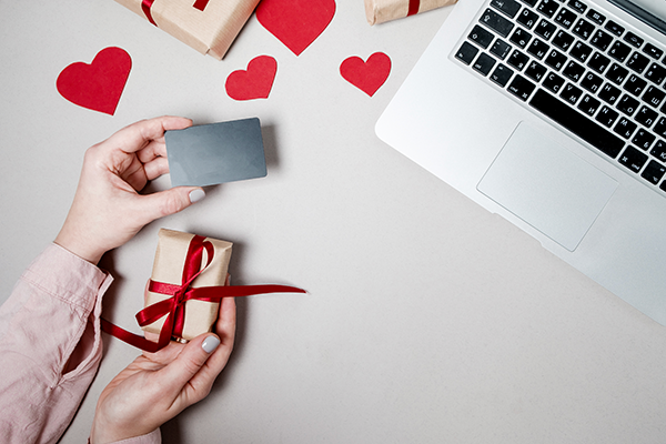 woman hands with credit card laptop gift box with heart coffee white background valentine day online shopping concept holiday background top view